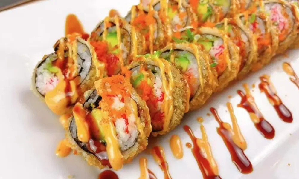 Crispy fried sushi roll with seafood, avocado, and drizzled sauces at A J House, a Asian Restaurant in Clarkesville